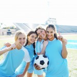 Smiling Female Soccer Players Holding Soccer
